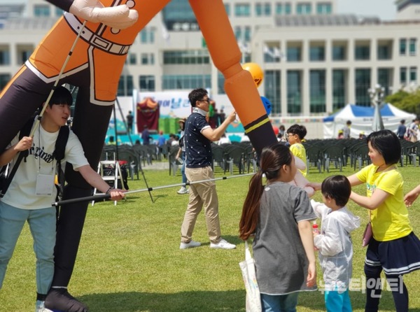 키다리 풍선인형과 악수하는 어린이  / 2019-05-05 ⓒ 뉴스티앤티