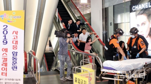 대전 서구는 13일 둔산동 갤러리아타임월드 백화점에서 ‘2019년도 에스컬레이터 사고 대응 합동훈련’을 실시했다.(사진=119 구조대가 부상자를 이송하고 있다) / 대전 서구 제공