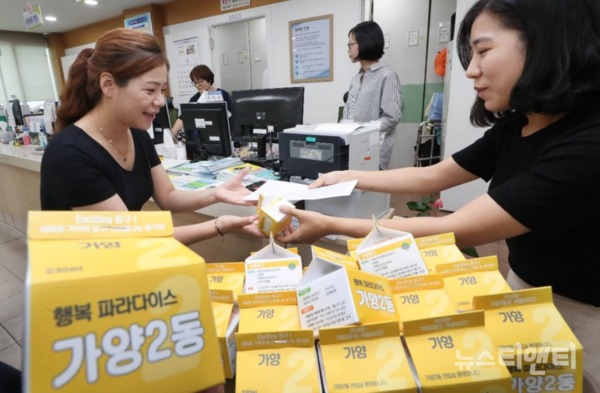 가양2동 직원이 한 주민에게 우유팩 모형의 메모지 홍보물품 전달하고 있다 / 대전 동구