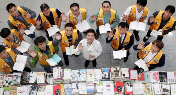 황인호 동구청장(사진 가운데)과 양지라이온스클럽 회원들이 책을 펼쳐보이며 기념촬영을 하고 있다 / 대전 동구 제공