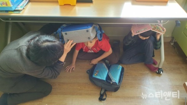 지진 발생 상황을 가정한 지지대피 훈련이 실시된 가운데 아이들이 책상 밑으로 피신하고 있다 / 계룡시 제공