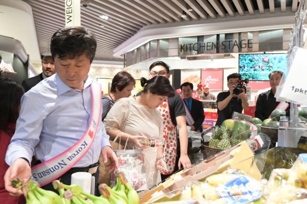 황명선 논산시장과 논산딸기 홍보판촉단이 11일 싱가포르 현지 마켓에서 딸기 포장, 수출가능한 농산물 등에 대해 분석하고 있다 / 논산시 제공