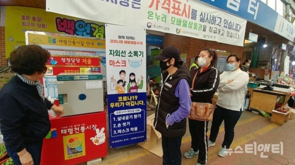 태평동 전통시장에서 방문객들이 마스크소독기 이용을 위해 기다리고 있다. / 대전 중구 제공