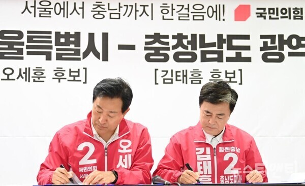 김태흠 국민의힘 충남지사 후보와 오세훈 서울시장 후보는 24일 충남과 서울간 광역교통망 협력을 위한 상생발전 협약을 체결하고 함께 실천하기로 약속했다.(사진=왼쪽부터 오세훈 후보와 김태흠 후보가 협약서에 서명하는 모습 / 김태흠 캠프 제공)