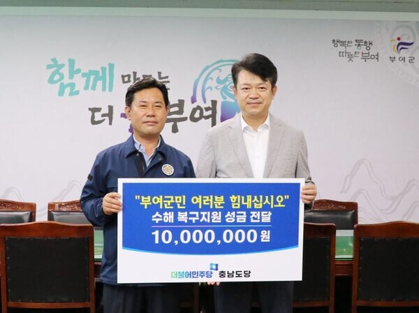 복기왕 더불어민주당 충남도당위원장이 26일 지난 집중호우로 피해를 입은 부여군을 방문하여 박정현 군수에게 1천만원의 복구지원 성금을 전달하고 있다(사진 왼쪽부터 박정현 부여군수, 복기왕 위원장). / 더불어민주당 충남도당 제공