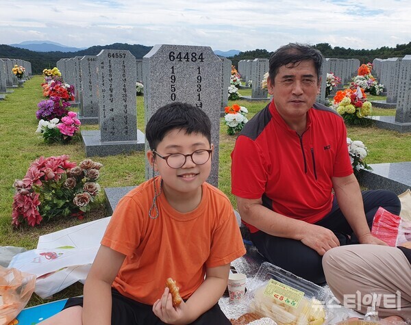 대전현충원을 찾아 성묘 후 음복 중인 김훈주씨(사진 오른쪽)와 아들 김도연군 / 뉴스티앤티