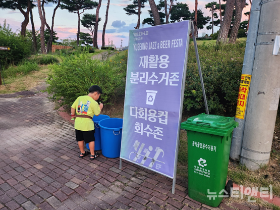 가족들과 나들이를 나온 어린이가 행사장에 마련된 분리수거존에 쓰레기를 버리고 있다. / 뉴스티앤티