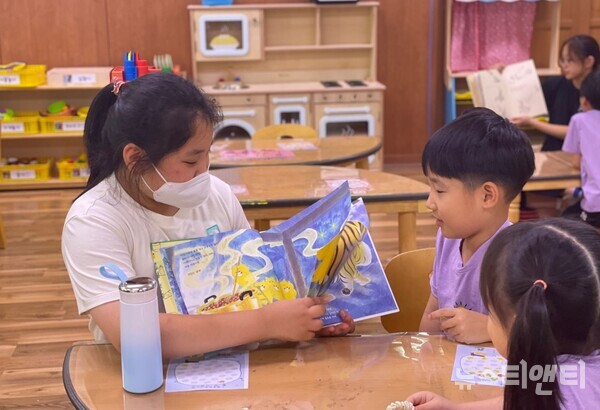 내포초등학교병설유치원 유아들이 초등학교 누나가 들려주는 동화책을 보고 있다. / 충남교육청 제공