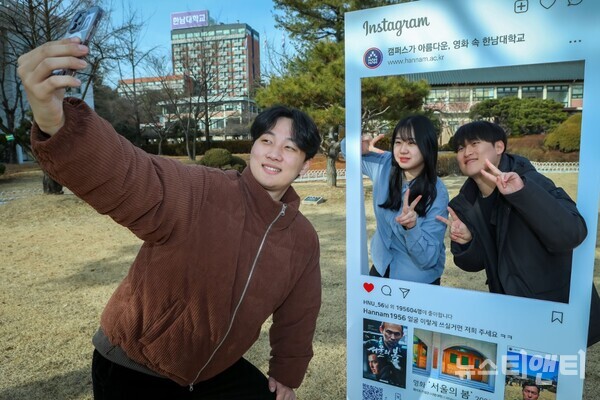 영화 '서울의 봄' 촬영지인 한남대학교 잔디밭 포토존에서 방문객들이 인증샷을 찍고 있다.