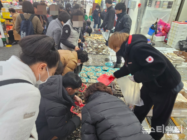 중앙시장 내부 한 수산물 점포. 손님들이 상인들과 가격 흥정을 하고 있다. / 뉴스티앤티