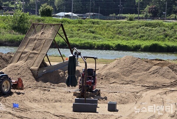 금산군 '파크골파장 확장사업' 시공업체가 사업부지 인근 하천에서 채취한 모래를 선별하는 모습 / 뉴스티앤티