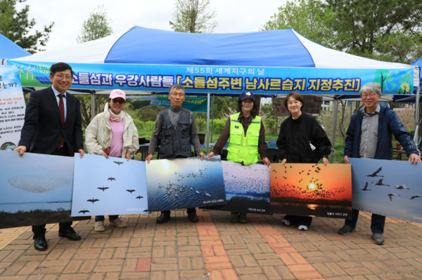 시민단체 '소들섬을 사랑하는 사람들'은 지난 19일 당진시 어름수변공원에서 열린 당진시 세계지구의 날 기념 생명축제에서 소들섬을 람사르 습지로 지정하자는 캠페인을 진행한 가운데, 생명축제 행사장 부스 앞에서 '소들섬을 사랑하는 사람들' 회원들이 소들섬의 아름다운 사진을 한 장씩 들고 기념촬영을 하고 있다. / '소들섬을 사랑하는 사람들' 제공