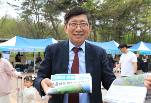 시민단체 '소들섬을 사랑하는 사람들'은 지난 19일 당진시 어름수변공원에서 열린 당진시 세계지구의 날 기념 생명축제에서 소들섬을 람사르 습지로 지정하자는 캠페인을 진행한 가운데, '소들섬을 사랑하는 사람들'의 조영종 공동대표가 소들섬 신문을 들어 보이고 있다. / '소들섬을 사랑하는 사람들' 제공