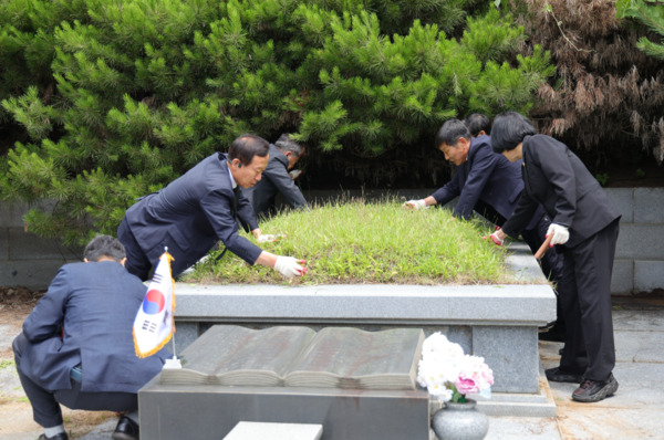 서천군의회는 지난 27일 한산면 종지리에 위치한 독립유공자 김갑수 지사의 묘소를 찾아 참배한 가운데, 김경제 의장을 포함한 7명의 의원들은 묘소 주변을 정비하고 있다. / 서천군의회 제공