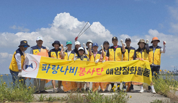 파랑나비봉사단은 지난 29일 당진 석문방조제에서 해안 쓰레기 수거 활동을 전개한 가운데, 조영종 단장을 비롯한 참석자들이 화이팅을 외치고 있다. / 파랑나비봉사단 제공