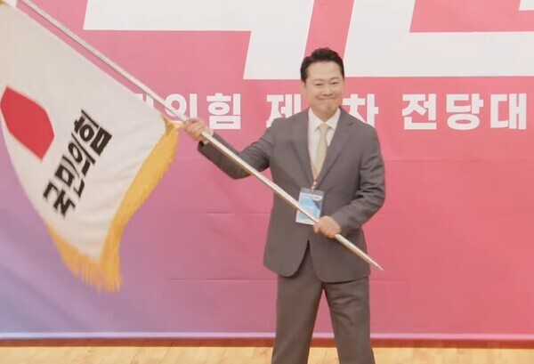 장동혁 국민의힘 신임 당대표가 26일 오전 국회도서관 대강당에서 열린 국민의힘 전당대회 결선에서 당기를 흔들고 있다. / 국민의힘TV 화면 갈무리