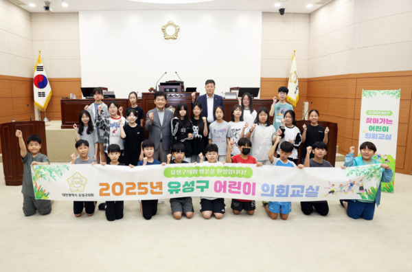 유성구의회는 '2025년 유성구 어린이 의회교실'을 성황리에 마무리하며, 미래의 주역인 아이들에게 민주주의의 가치와 의회 민주주의의 중요성을 알리는 뜻깊은 시간을 가진 가운데, 김동수 의장과 여성용 부의장을 비롯한 어린이들이 화이팅을 외치고 있다. / 유성구의회 제공