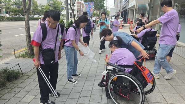 ‘동행 플로깅·문화체험’에 참여한 장애인시설 이용자와 동대문구청 직원들이 함께 거리 청소 활동을 하고 있다. / 동대문구청 제공