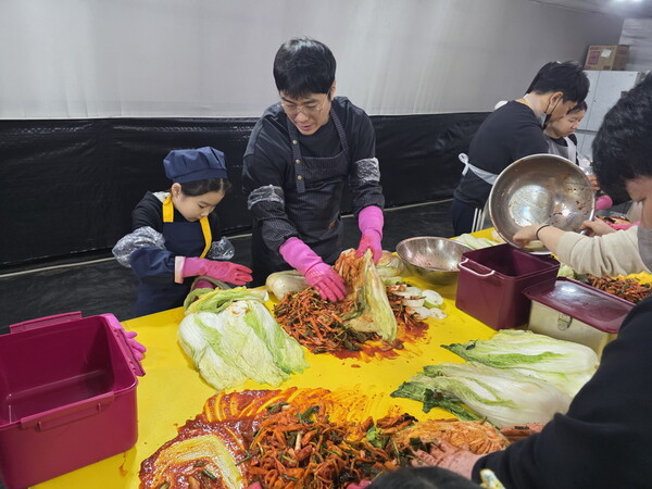 시흥시학교급식지원센터가 주관한 '제5회 시흥시 로컬푸드 김장체험'에서 한 시민이 자녀와 함께 시흥 농산물로 김장을 담그고 있다. / 시흥시청 제공