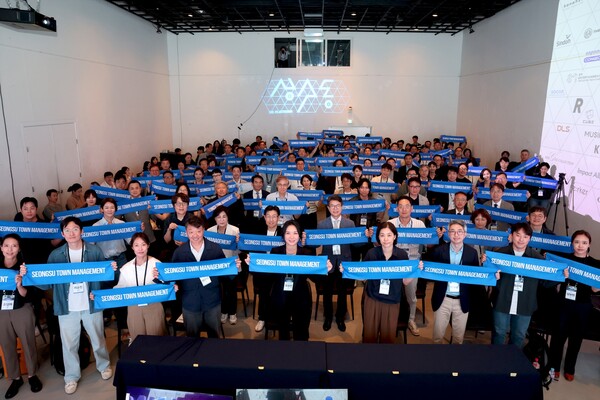 성동구가 지난 6월 개최한 ‘성수 타운매니지먼트’ 출범식에서 참여 기업·기관·주민들이 함께 현수막을 들고 기념 촬영하며 지역통합관리 추진 의지를 공유하고 있다. / 성동구청 제공