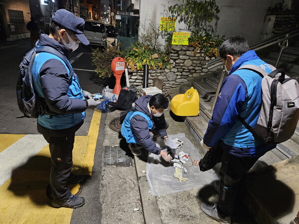 성북구청 단속반이 야간 현장에서 무단투기 쓰레기를 확인하며 투기 경위를 조사하고 있다. / 성북구청 제공