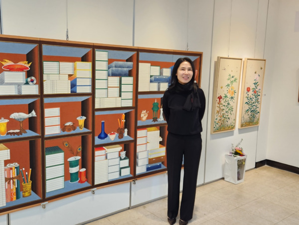 홍성궁중채색민화협회는 19일부터 오는 21일까지 홍성문화원 전시실에서 ‘민화 궁중 채색화 展’을 개최한 가운데, 신광숙 회장이 작품 앞에서 기념촬영을 하고 있다. / ⓒ 뉴스티앤티
